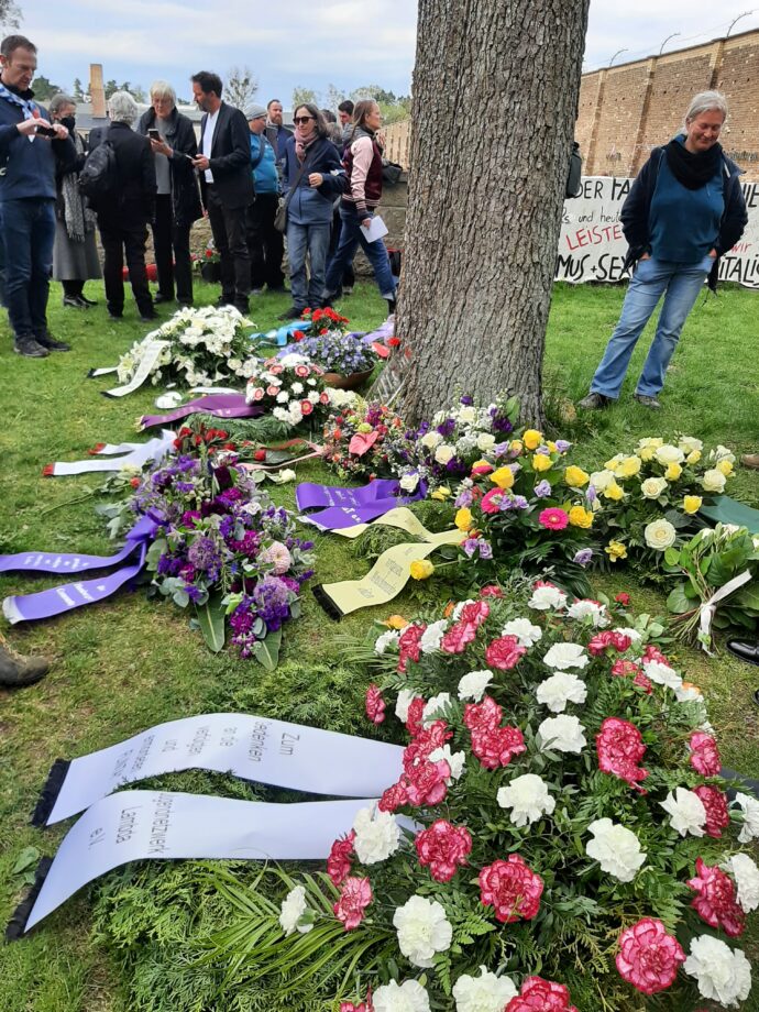 Gedenkfeier in Ravensbrück - Blumenkränze unter einem Baum